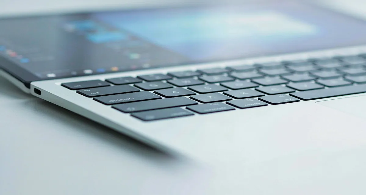 Configurar teclado español latinoamericano Windows 10 y 11: teclado de laptop con la tecla ñ y la ventana de idioma de Windows